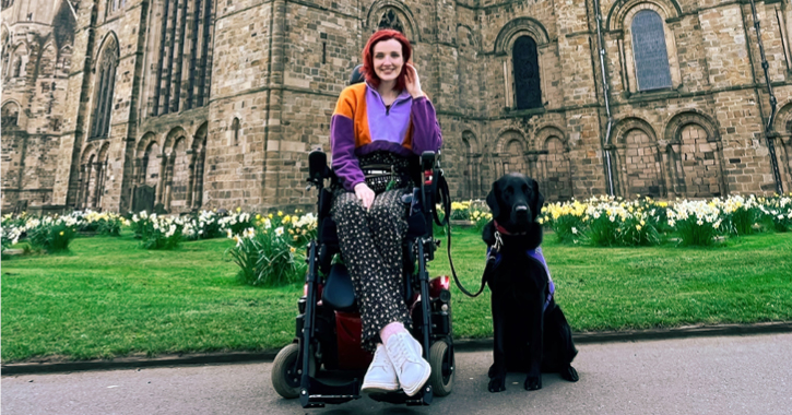 Disabled blogger Kate Stanforth sat in her wheelchair outside Durham Cathedral with her service dog.